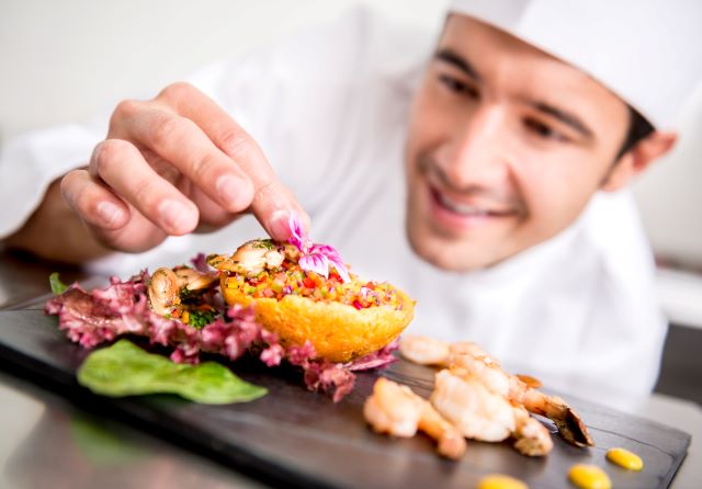 un employé de cuisine ou chef cuisiner dressant son assiette